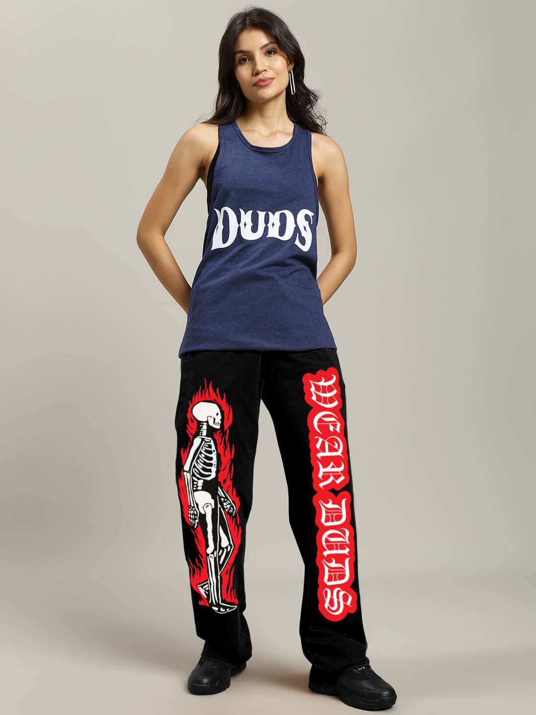 Woman wearing WOMENS FLAMING SKELETON PRINTED RELAXED FIT JOGGER BLACK, edgy streetwear with bold red skeleton graphic.