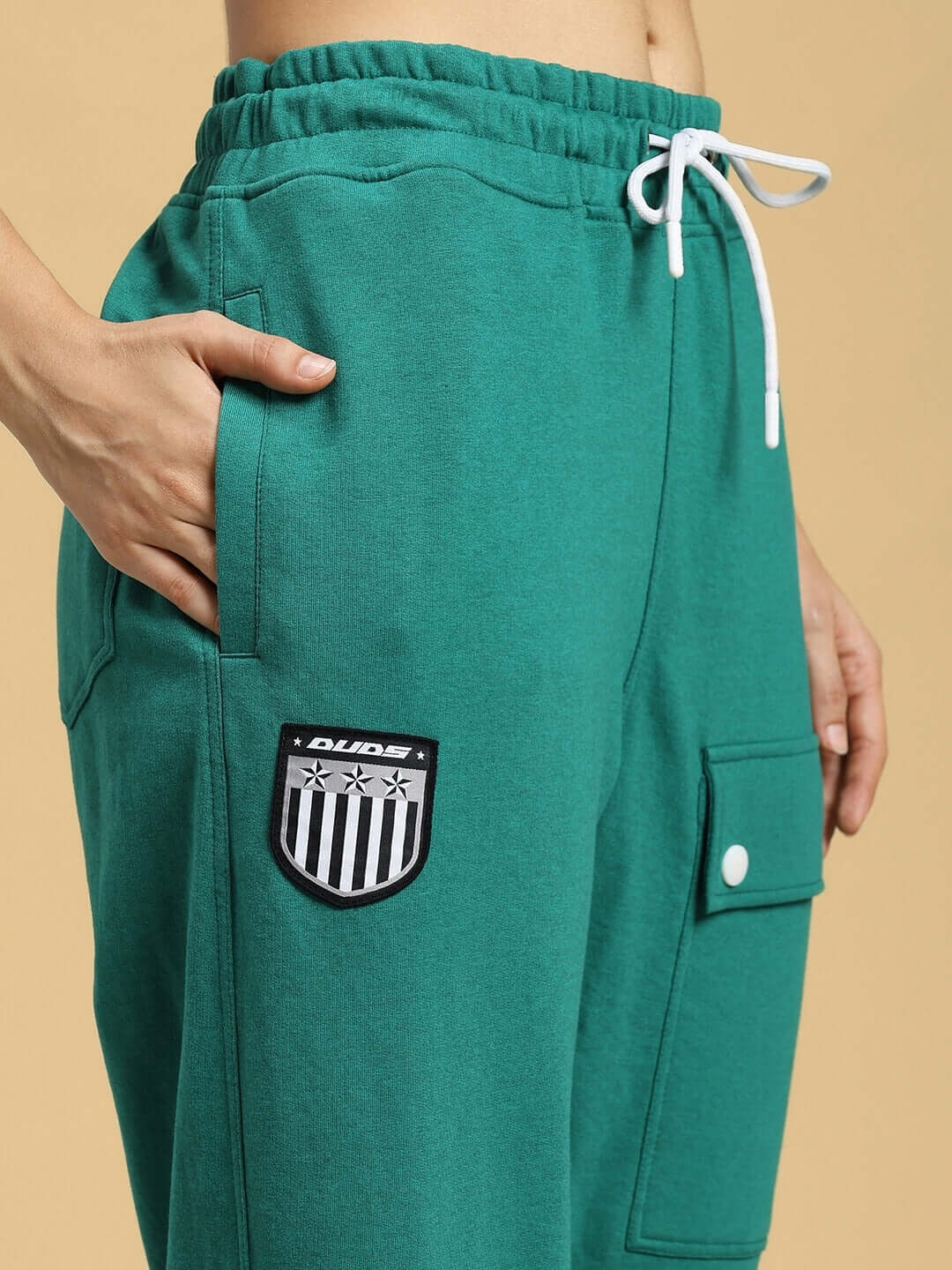 Close-up of WOMENS AWESOME FLAP POCKET BAGGY JOGGER GREEN with hand in pocket.