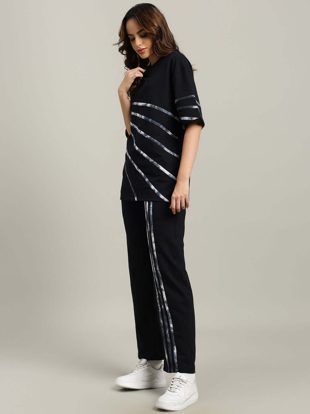 WOMEN'S FLICKER OVERSIZED CO-ORD SET BLACK, model wearing black oversized co-ord set, relaxed fit joggers, and sneakers.