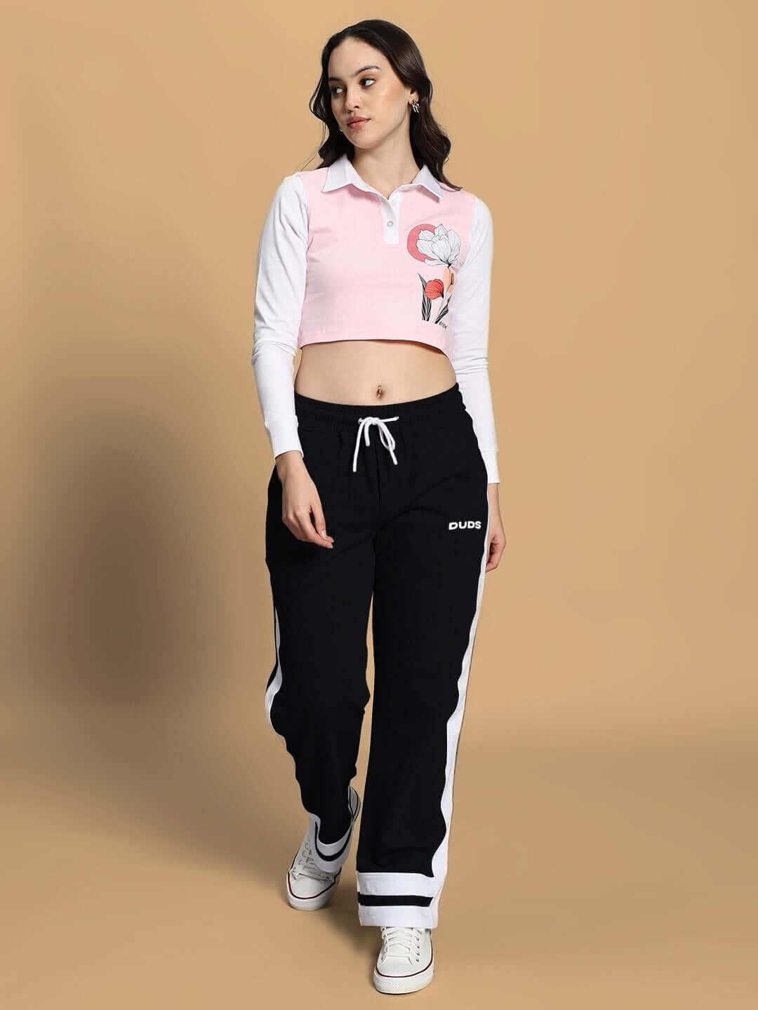 Model wearing Women's Flora Co-Ord Set Pink Black, showcasing streetwear fashion by WEAR DUDS on beige background.