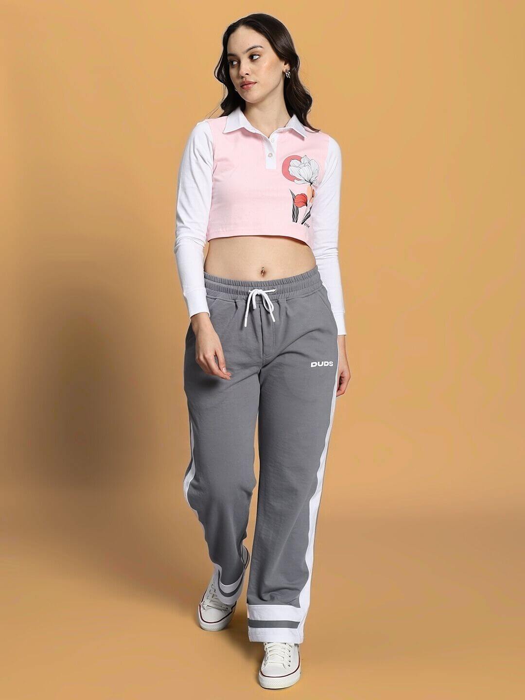 Woman wearing WOMEN'S FLORA CO-ORD SET PINK GREY from WEAR DUDS, featuring a pink top and grey pants, stylish streetwear fashion.