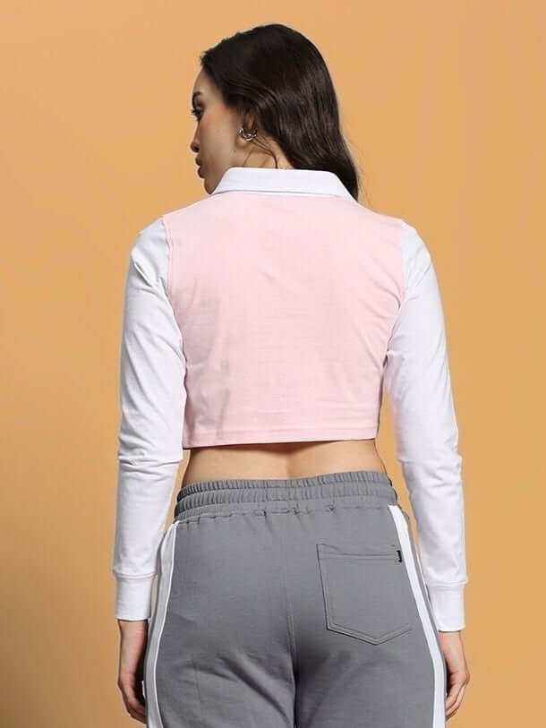 Back view of women's pink and white crop top with regular sleeves, crafted from premium cotton and elastane fabric, styled with grey pants.