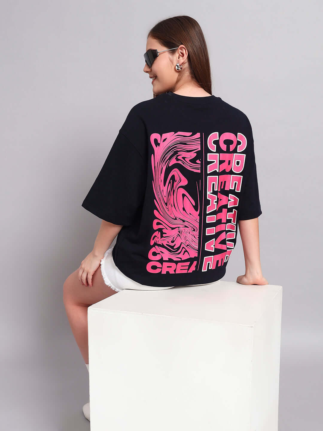 Woman wearing navy blue oversized t-shirt with creative pink print, made from premium cotton French terry by Color By Colours.