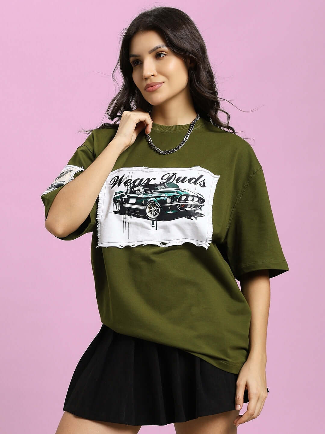 Woman wearing an olive green Ford Mustang oversized T-shirt made of premium cotton fabric, featuring a bold design, showcasing casual style.