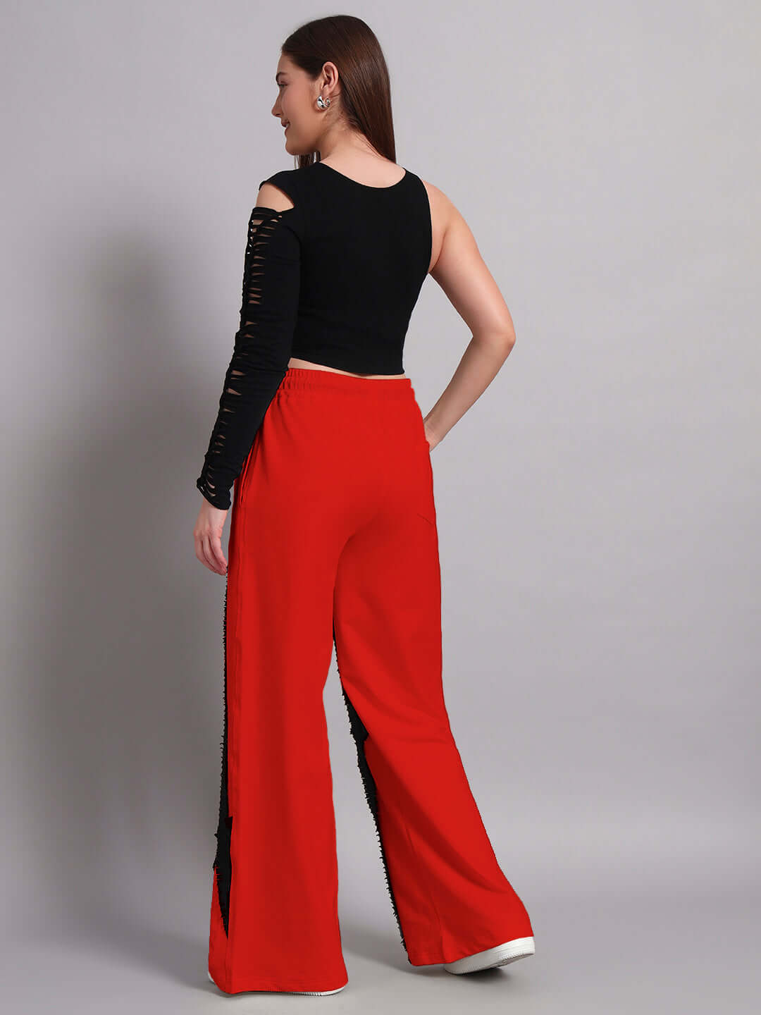 Woman wearing black and red frayed textured stripes co-ord set with relaxed fit joggers, showcasing back view. Fashionable women's outfit.