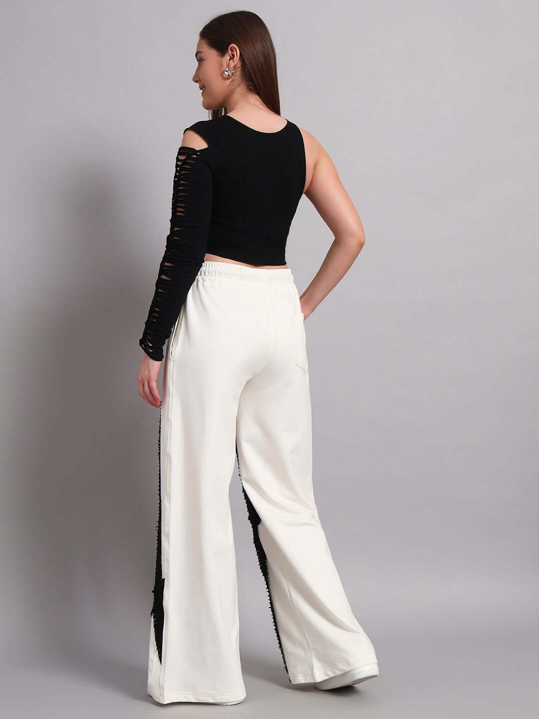 Model wearing women's frayed textured stripes co-ord set in off white and black, showcasing relaxed fit joggers and black top from back view.