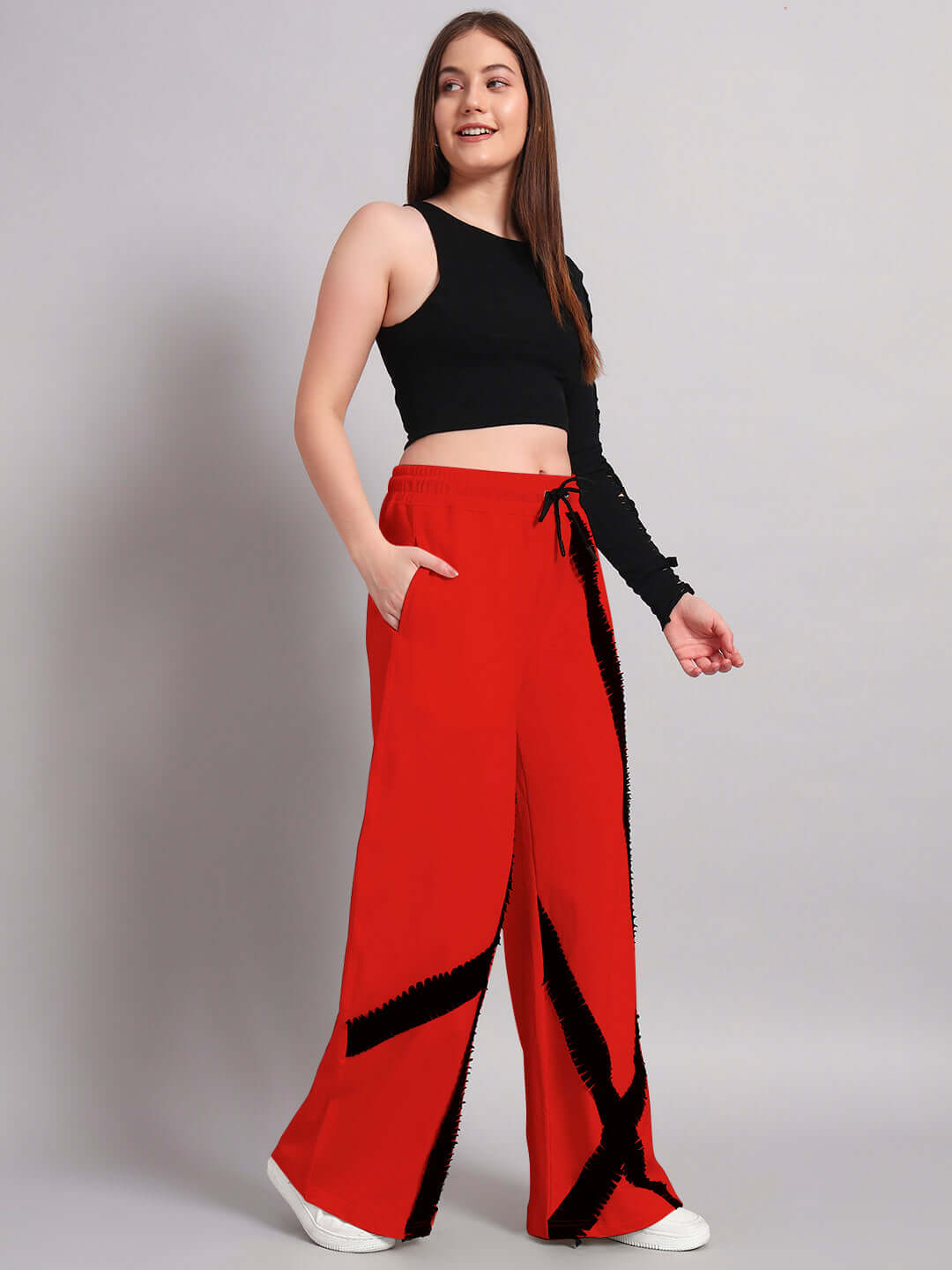 Woman wearing black and red frayed textured striped co-ord set, featuring a relaxed fit with drawstring joggers. Fashionable and stylish outfit.