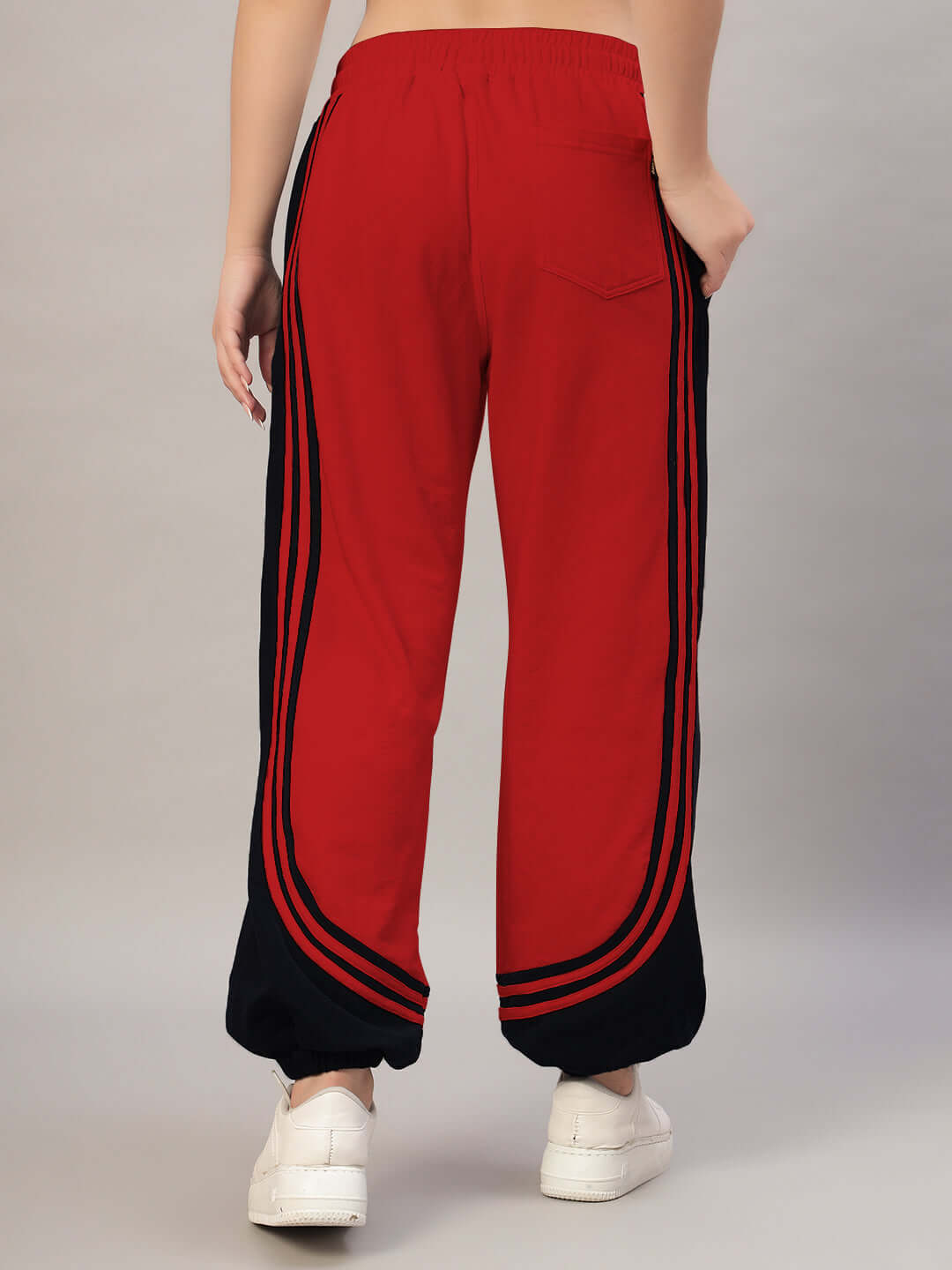 Women's red and black contrast joggers with side stripes, showcasing custom fit option from DUDS.