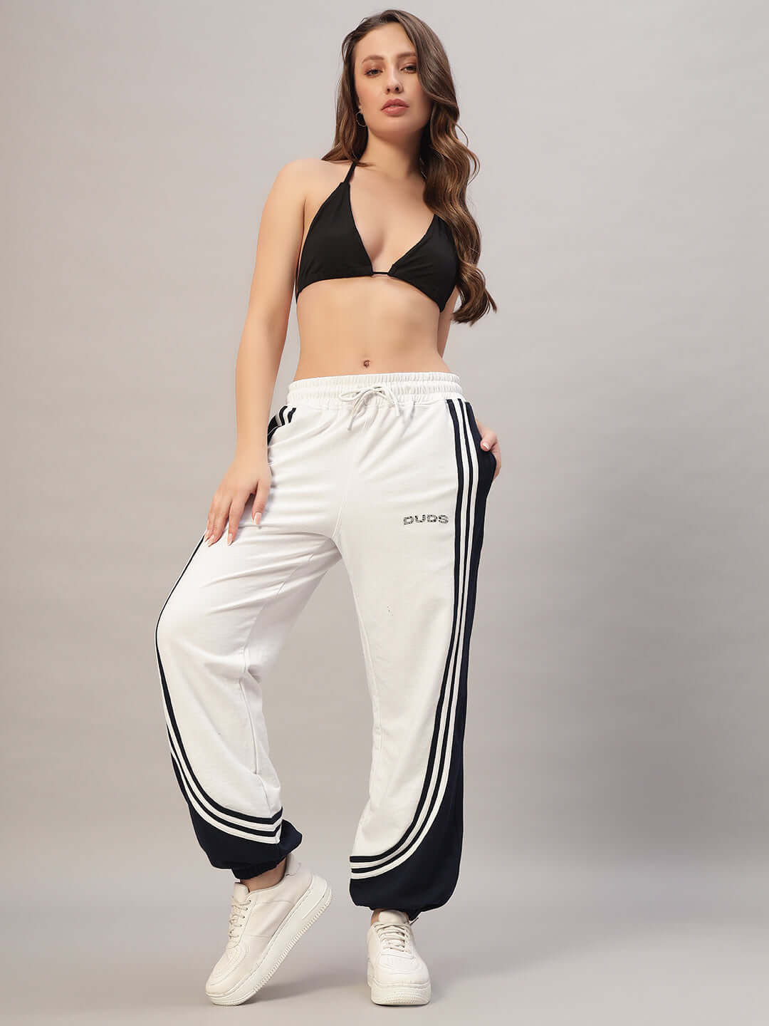 Model wearing Women's Frenzy Curve Contrast Joggers in white and navy, styled with a black top and white sneakers.