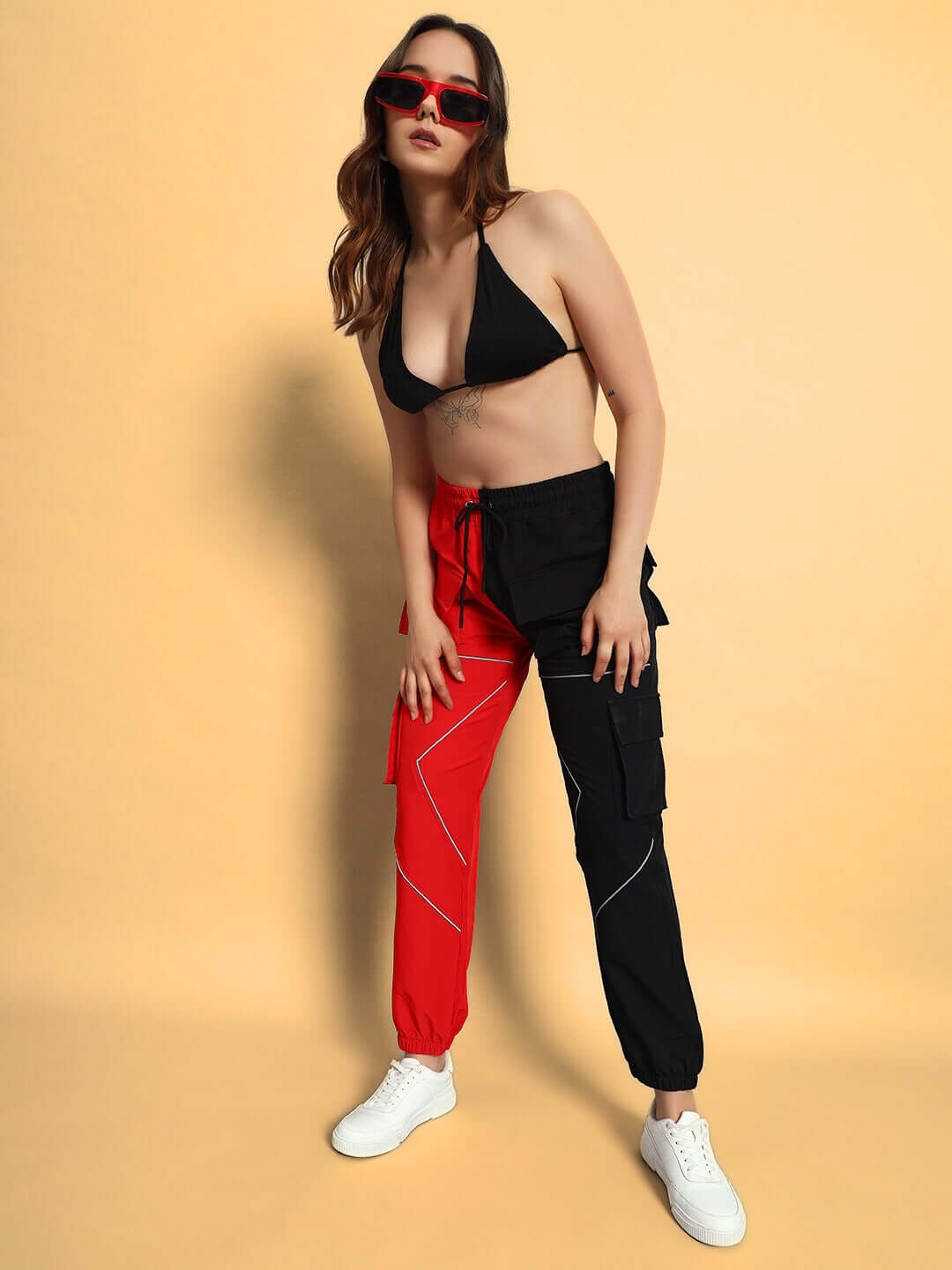 Model wearing Women's Frontline Reflector Parachute Cargo Pants in red-black with custom fit option, stylish and handmade fashion.