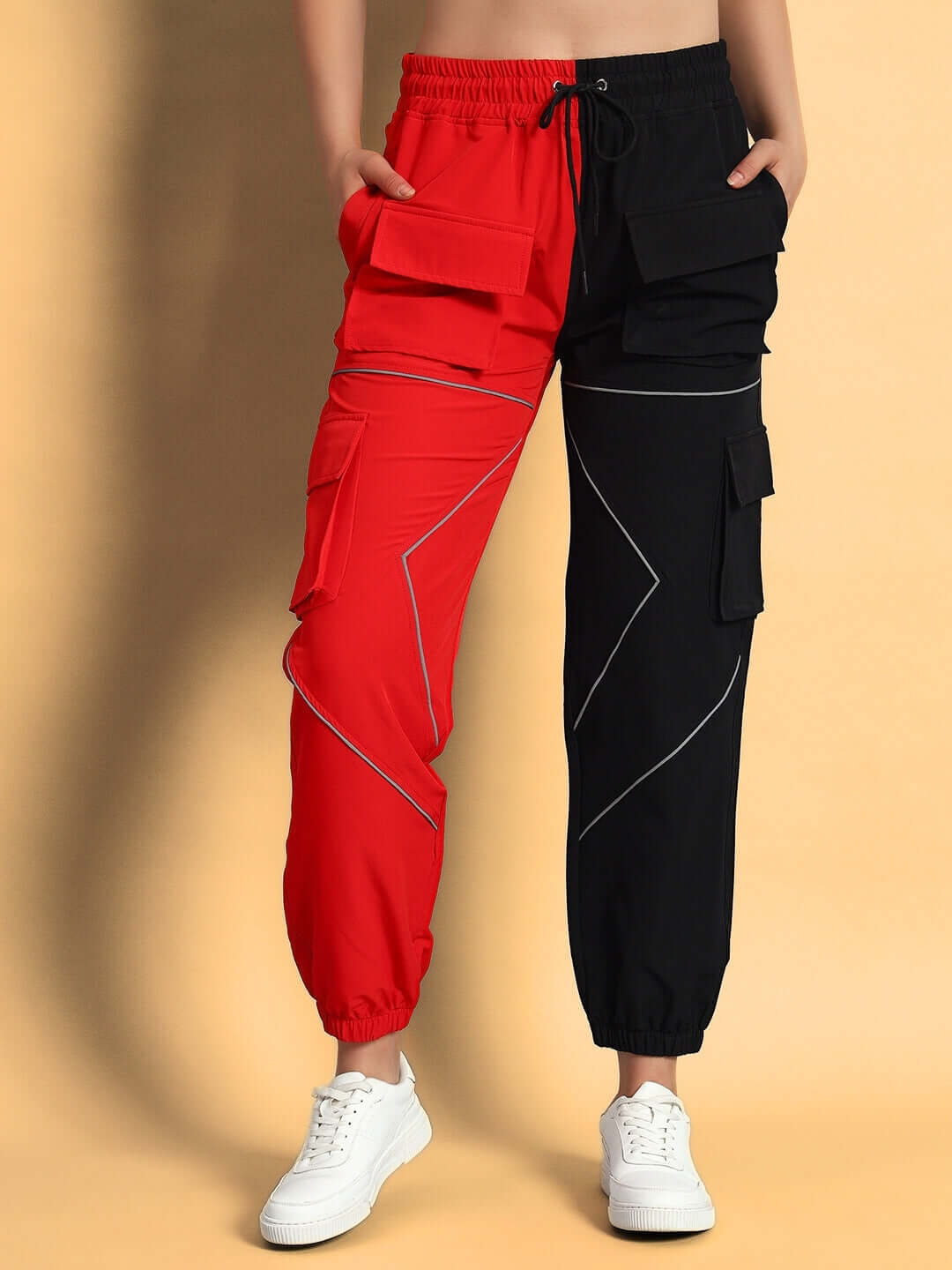 Red-black women's parachute cargo pants with reflective detailing and multiple pockets, customizable for perfect fit, worn with white sneakers.