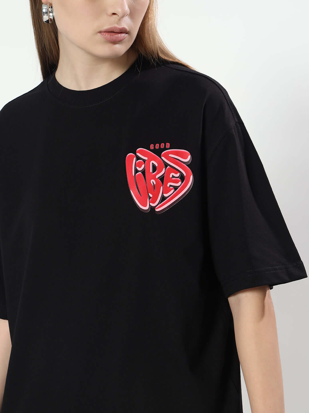 Women's oversized black t-shirt with 'Good Vibes' red graphic design.
