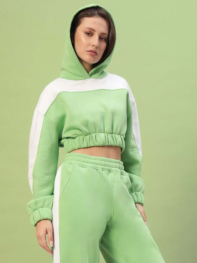 Woman wearing green women's Rizzler colorblock co-ord set with hooded top and pants, featuring modern color blocking for casual style.