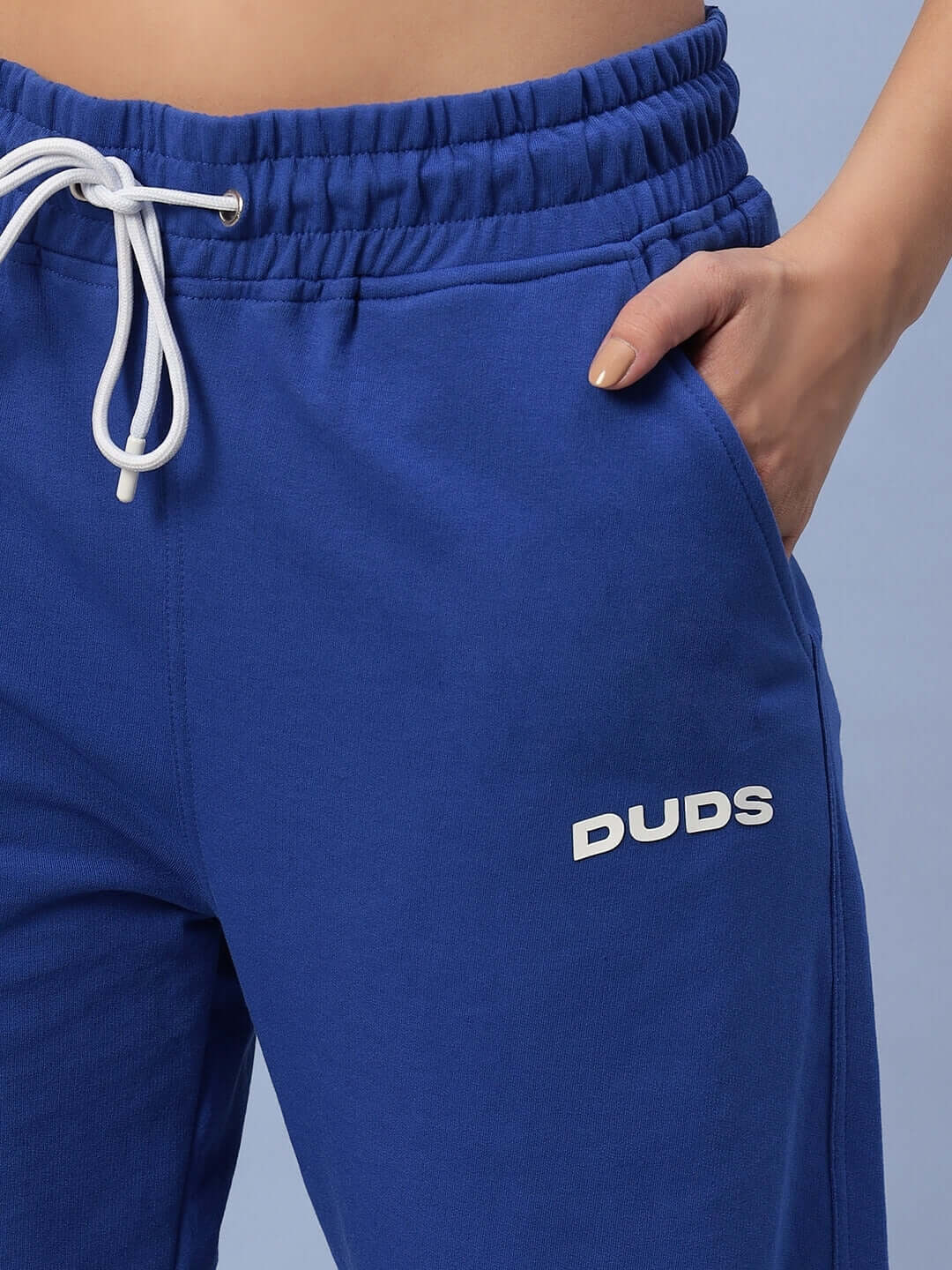 Close-up of women's royal blue Hershey side slit joggers by DUDS with elastic waistband and drawstring.