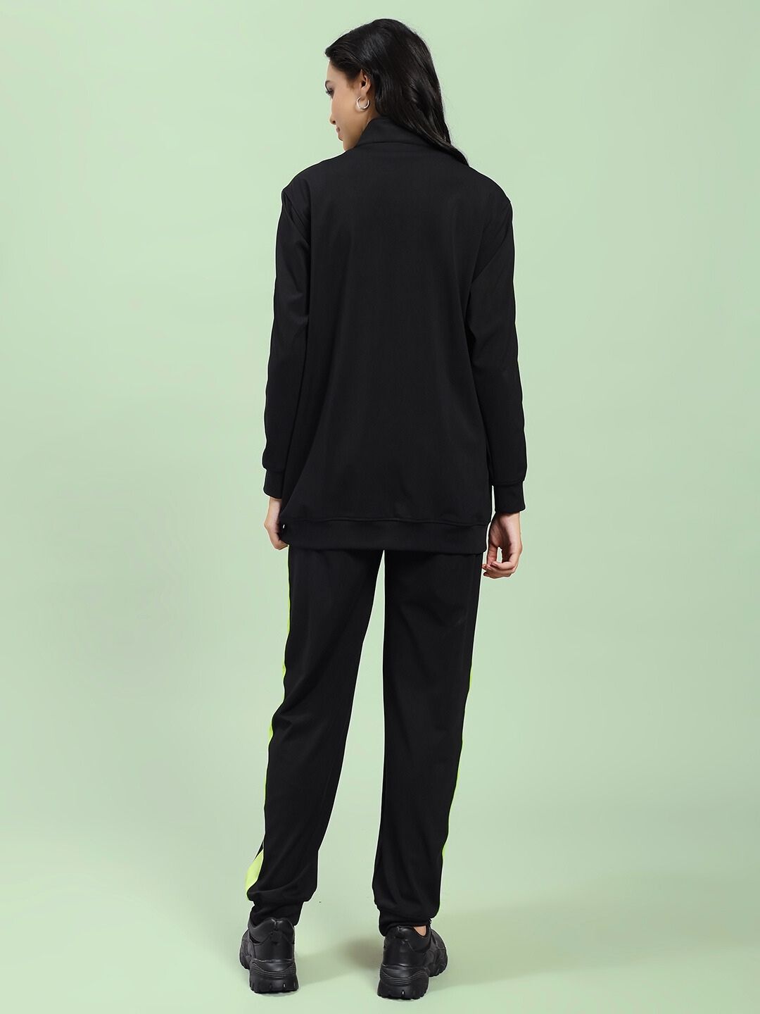 Back view of model wearing WOMEN HIGH PERFORMANCE CO-ORD SET BLACK with a zip-up hoodie and tapered joggers, showcasing sleek athleisure design.