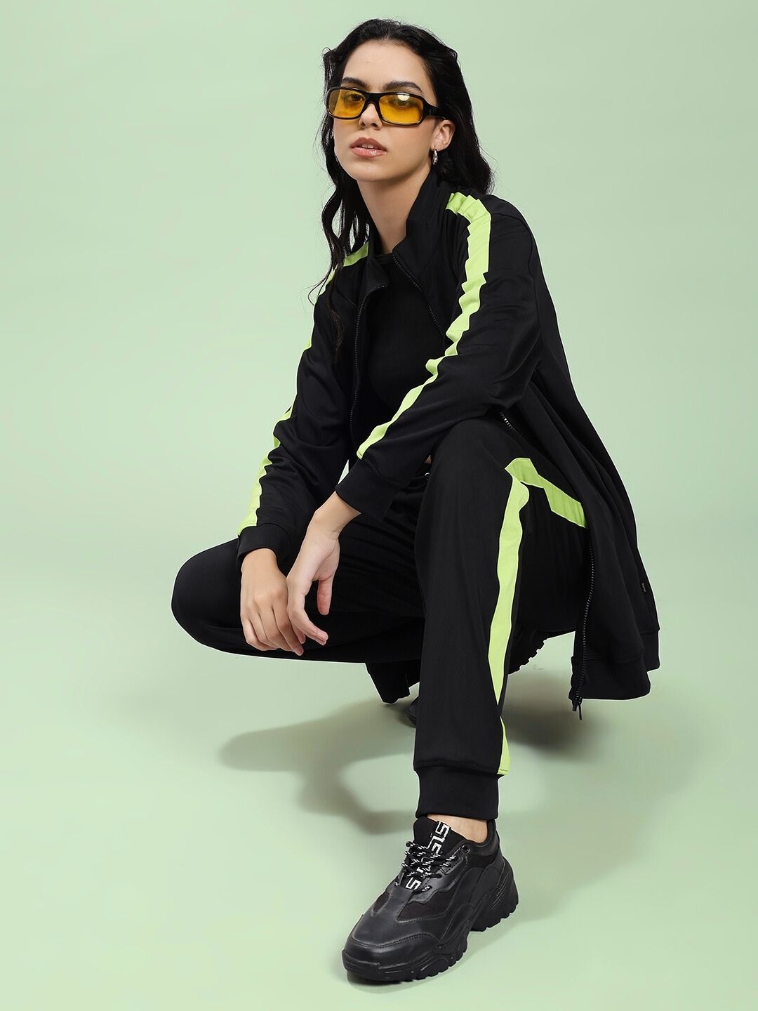 Model wearing WOMEN HIGH PERFORMANCE CO-ORD SET BLACK with neon stripes, showcasing athleisure style.