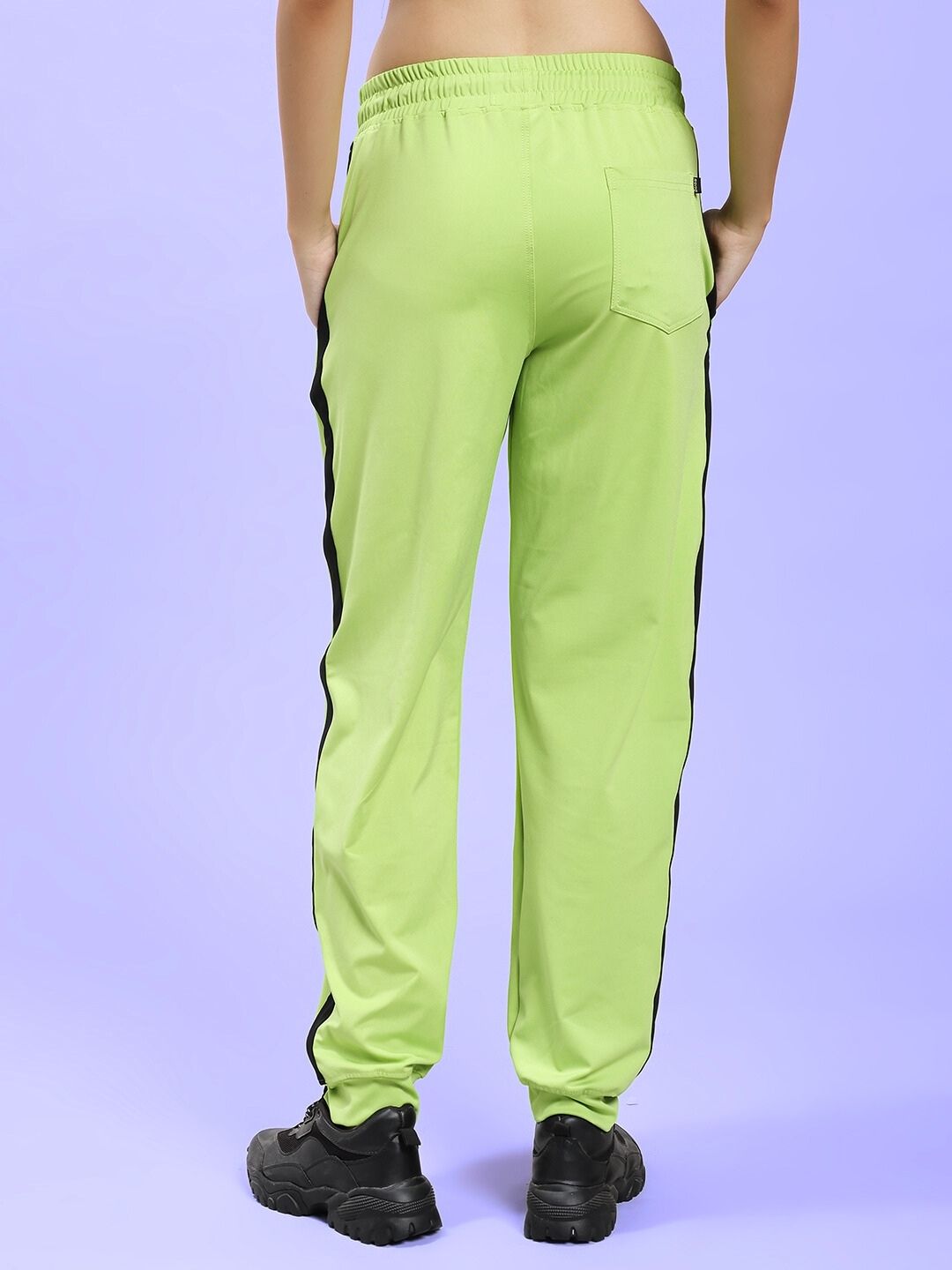 Back view of WOMEN'S HIGH PERFORMANCE RELAXED FIT JOGGER NEON GREEN with black side accents, showcasing comfortable and breathable fabric.