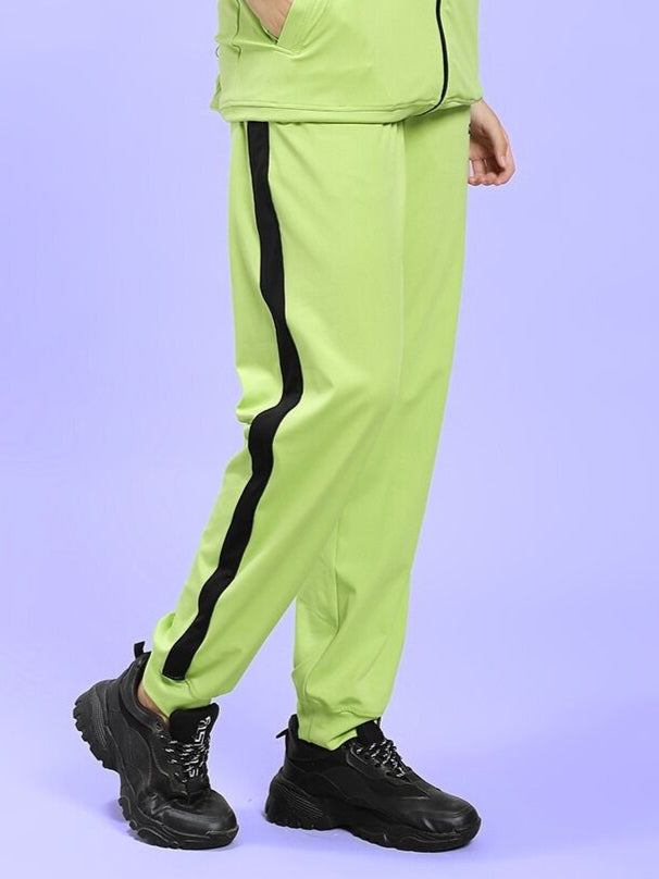 Model wearing WOMEN'S HIGH PERFORMANCE RELAXED FIT JOGGER NEON GREEN with black stripe and black sneakers