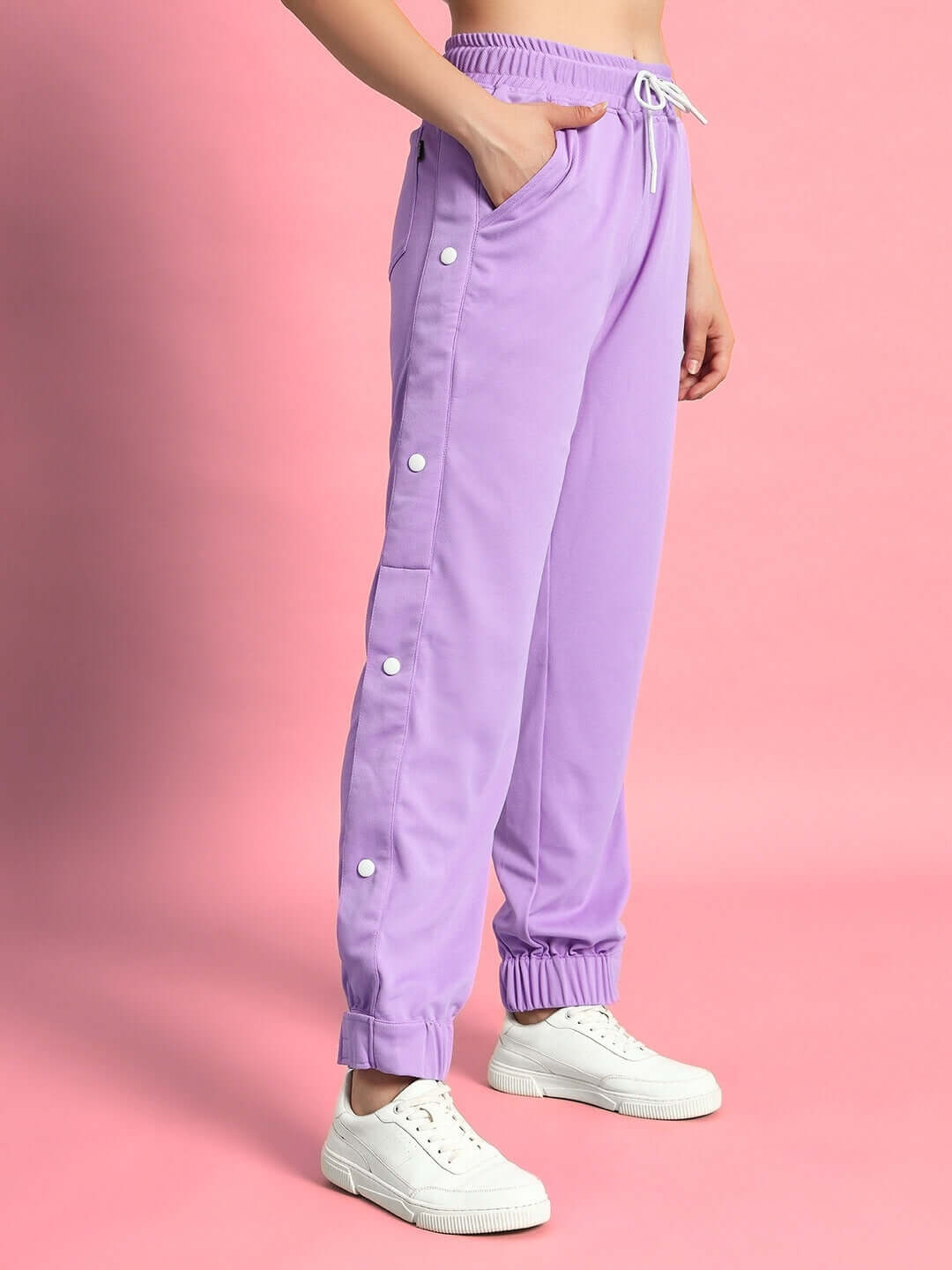 Lavender women's hip hop joggers with side buttons and elastic cuffs, paired with white sneakers. Perfect for casual street style.