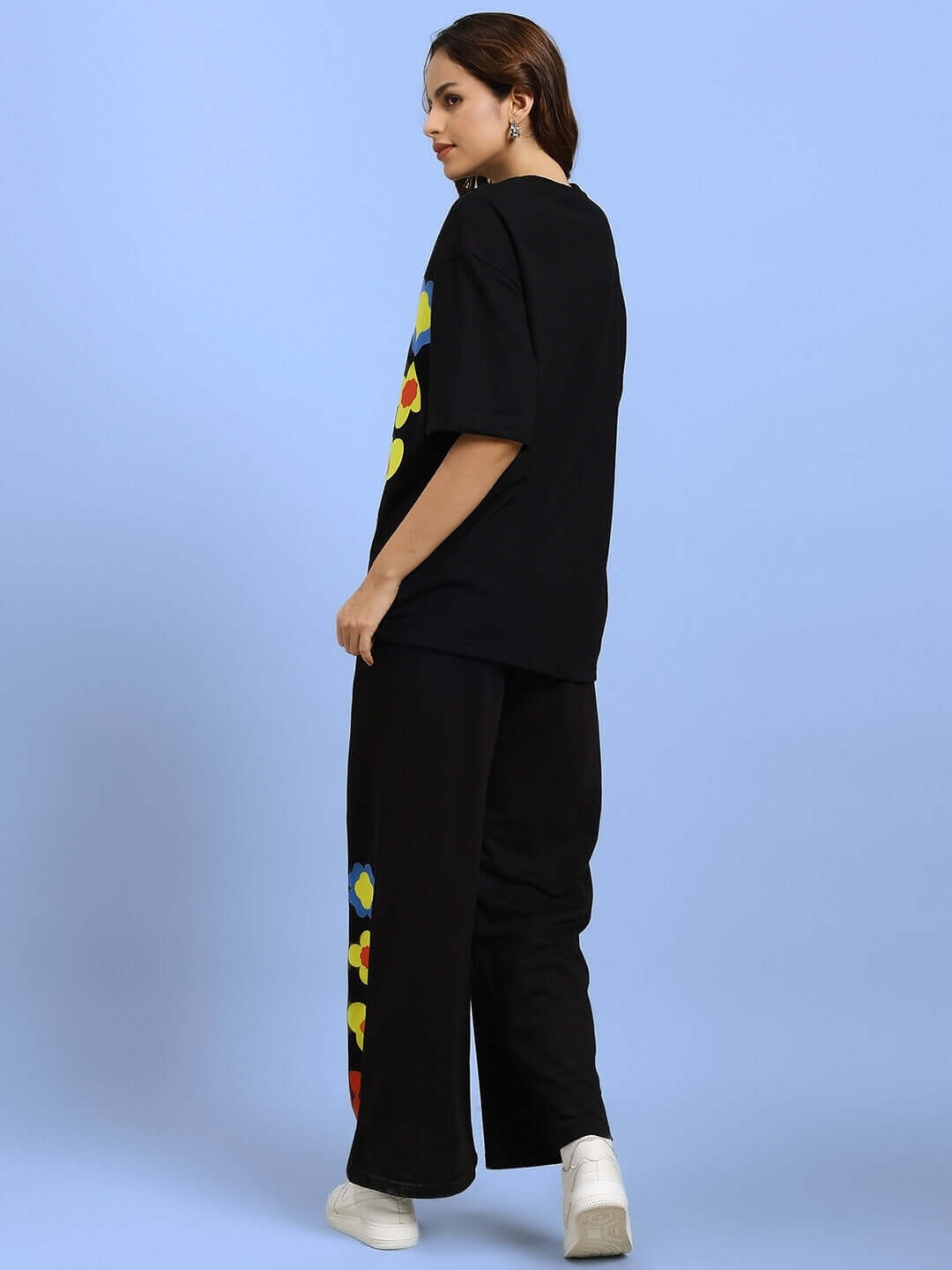 Model wearing WOMEN'S HOLLISTER CO-ORD SET BLACK, showcasing back view with oversized t-shirt and joggers with colorful accents.