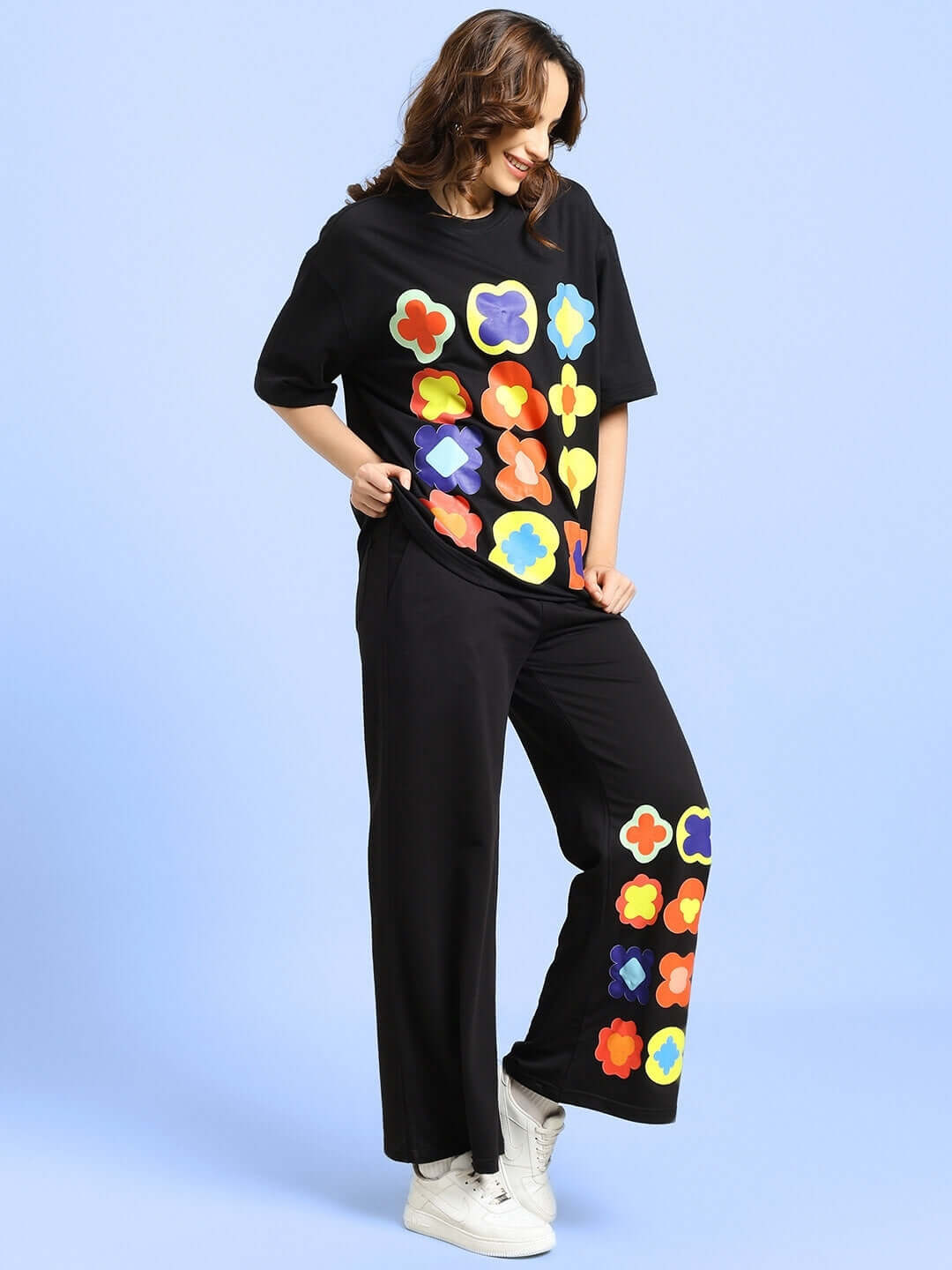 Woman wearing a black co-ord set with colorful flower design, similar to WOMEN'S HOLLISTER CO-ORD SET BLACK.