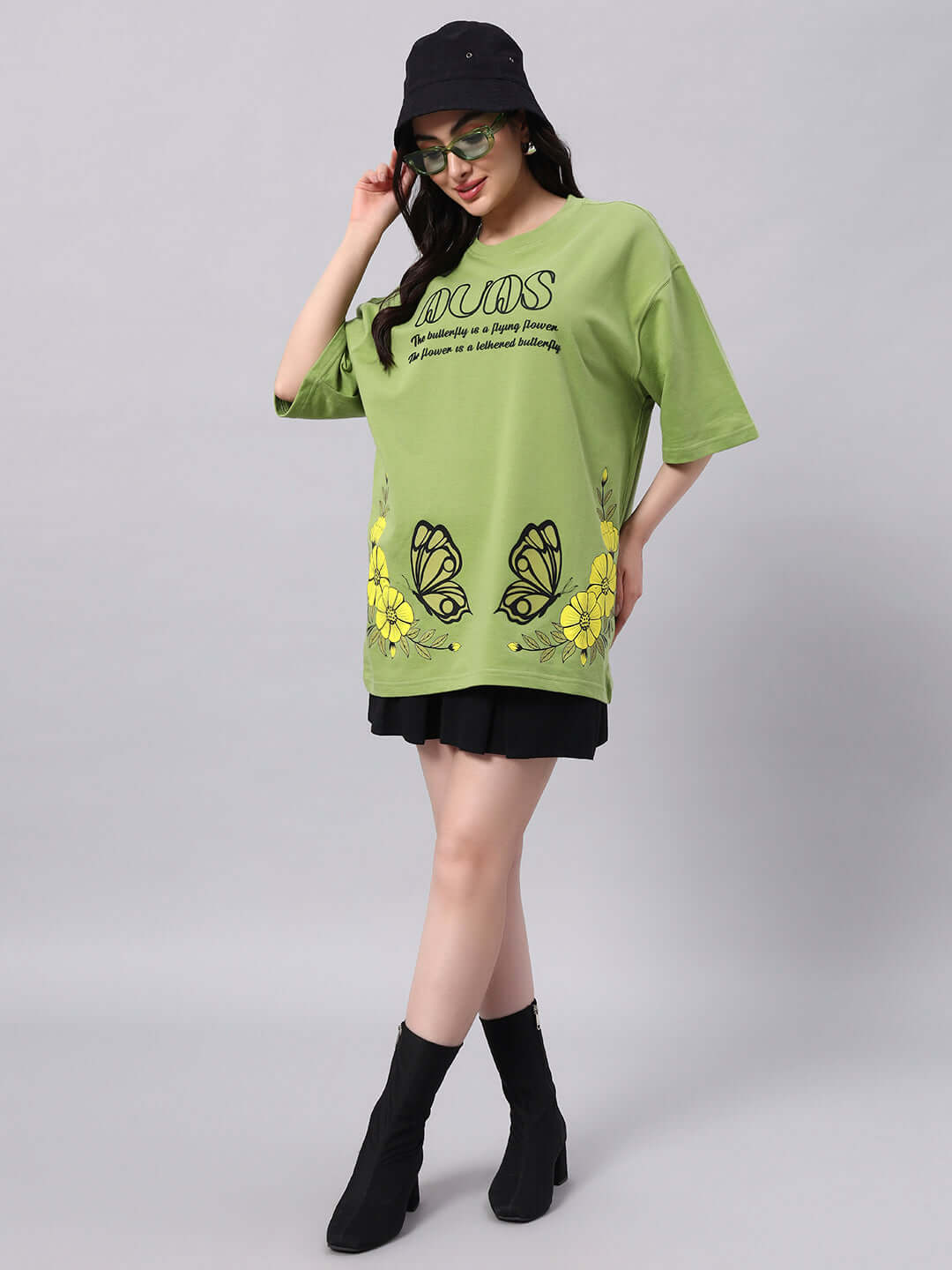 Model wearing WOMEN'S IKON BUTTERFLY T-SHIRT GREEN with butterfly print and floral accents, made from premium cotton fabric.