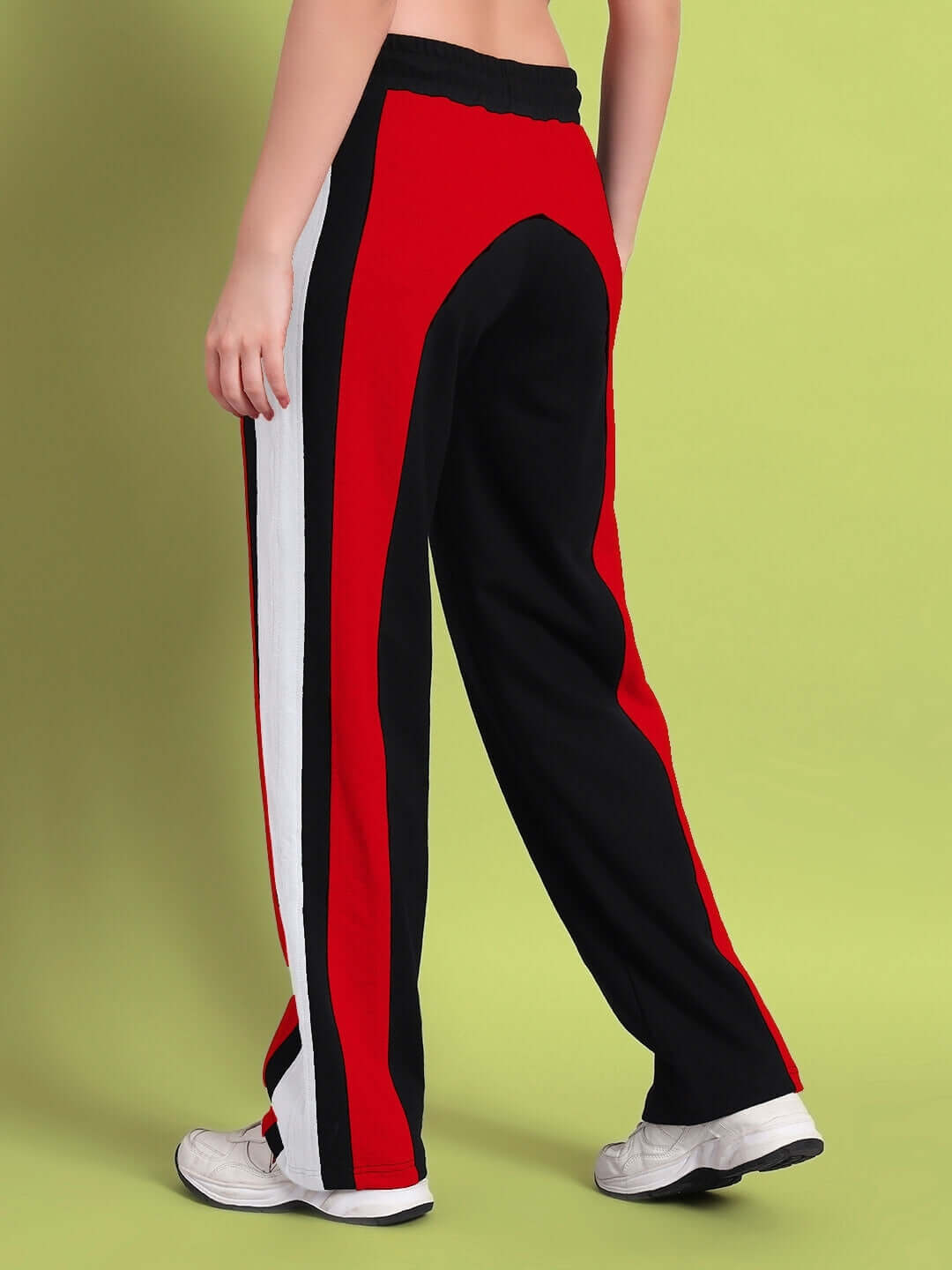 Woman modeling black and red color block relaxed-fit joggers by DUDS, stylish side view showcasing bold stripes on comfortable fabric.
