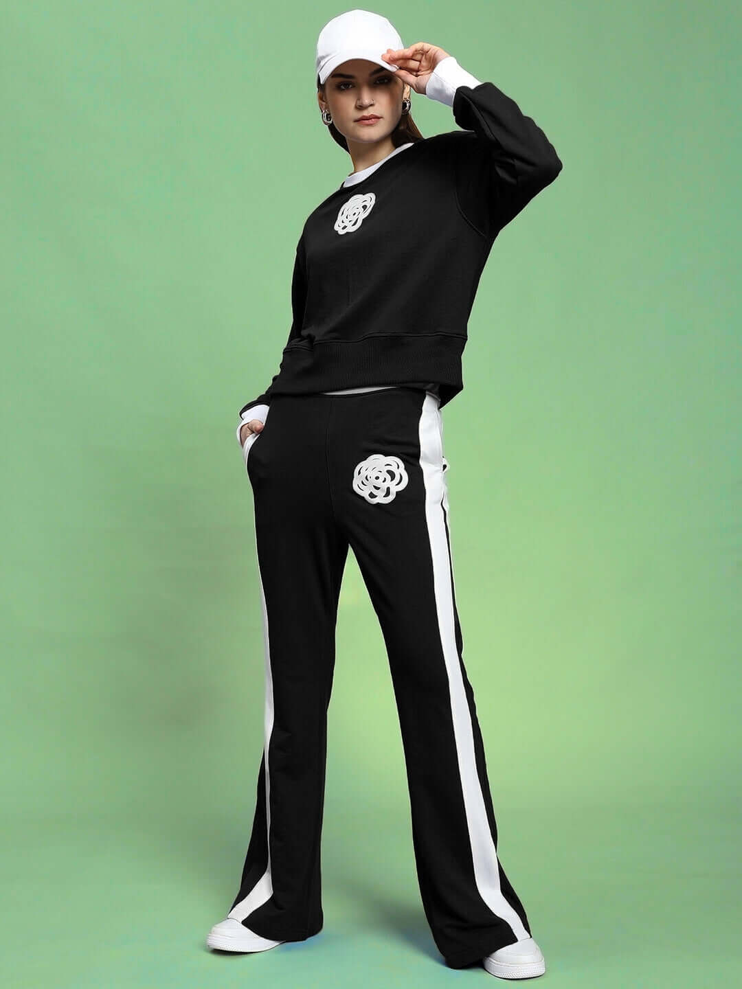 Model wearing WOMEN'S JESSFLICK RELAXED FIT SWEATSHIRT BLACK with matching black and white striped sweatpants.