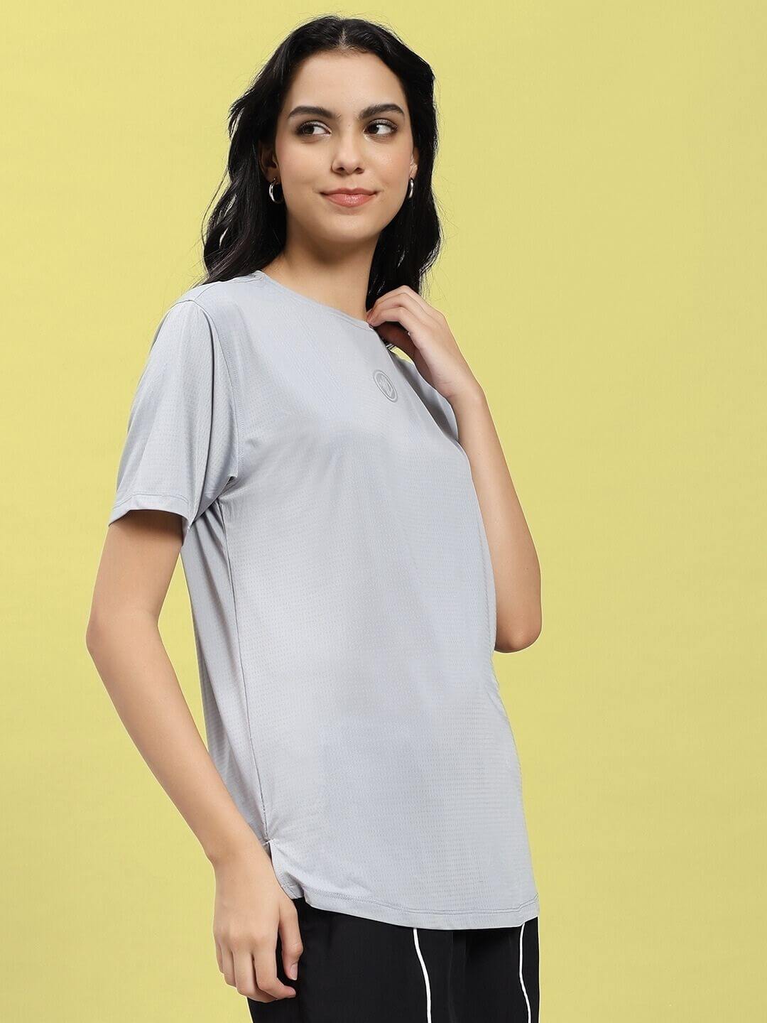 Woman wearing WOMEN JET RUN REGULAR FIT T-SHIRT GREY against a yellow background
