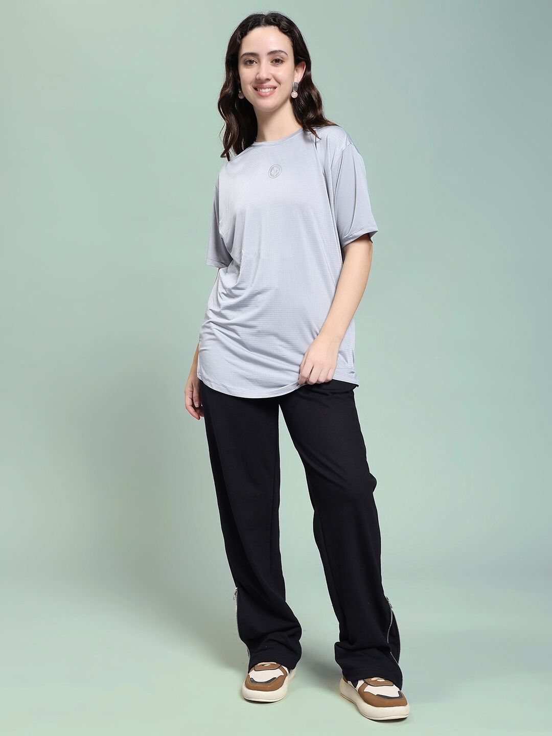 Model wearing WOMEN'S JOSS WINS RELAXED-FIT JOGGER BLACK with a casual top, standing against a light green background.