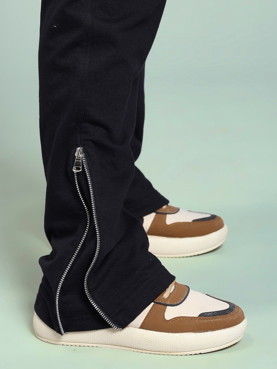 Close-up of WOMEN'S JOSS WINS RELAXED-FIT JOGGER BLACK with side zipper detail and sneakers.