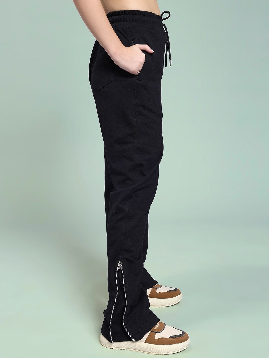 Side view of WOMEN'S JOSS WINS RELAXED-FIT JOGGER BLACK with zipper detail, worn by model with sneakers.
