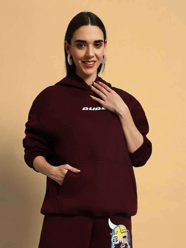 Woman in wine-colored fleece co-ord set featuring a hoodie and matching pants with cartoon design, perfect for casual wear.