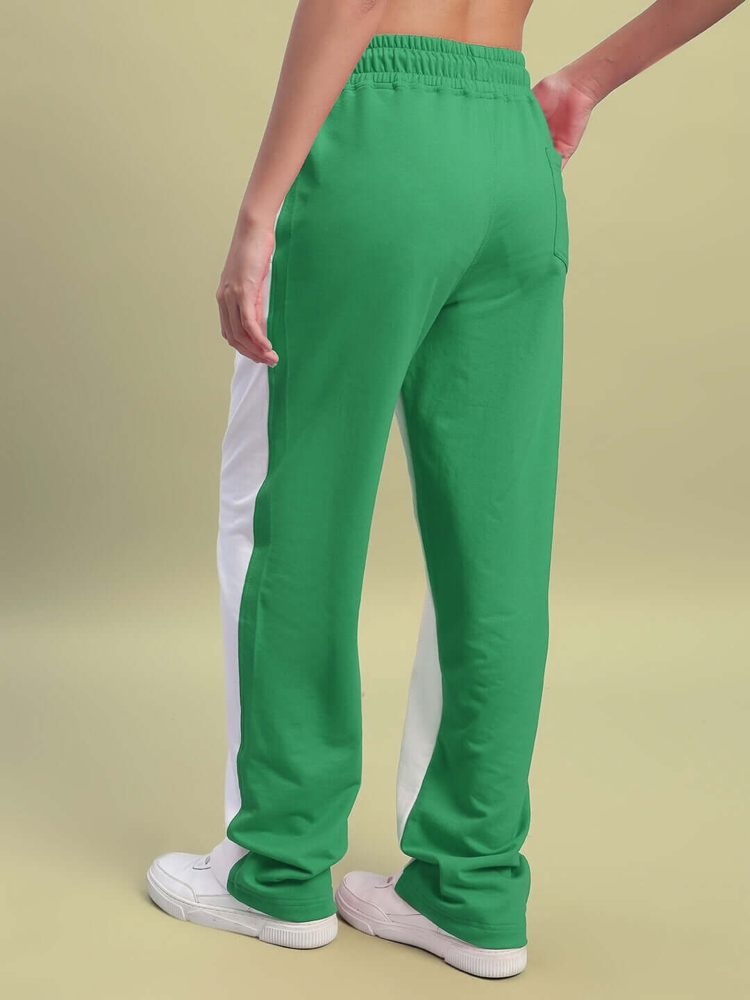 Back view of woman wearing Women's Lagoon Relaxed Fit Joggers in white and green, showcasing elastic waistband and sporty style.