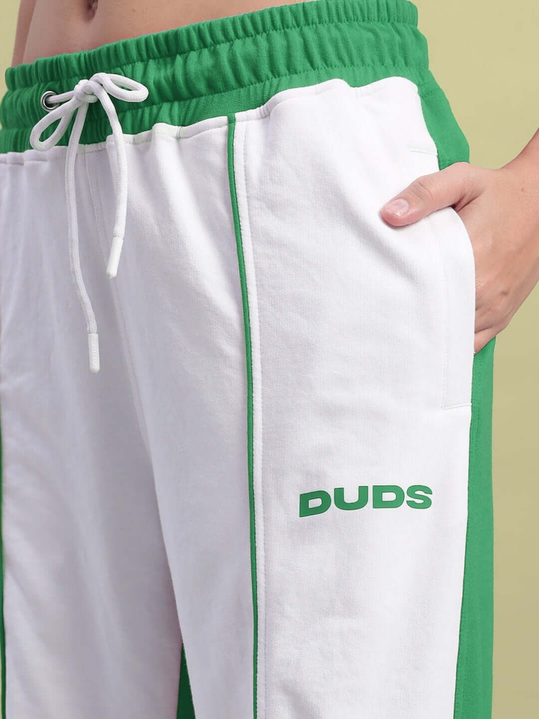 Close-up of Women's Lagoon Relaxed Fit Joggers in white and green featuring DUDS logo and drawstring.