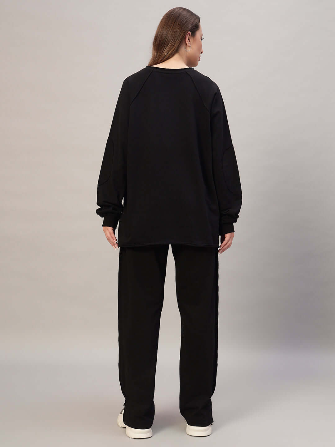 Back view of a woman wearing a black oversized co-ord set with a relaxed fit, highlighting a comfortable and stylish look.