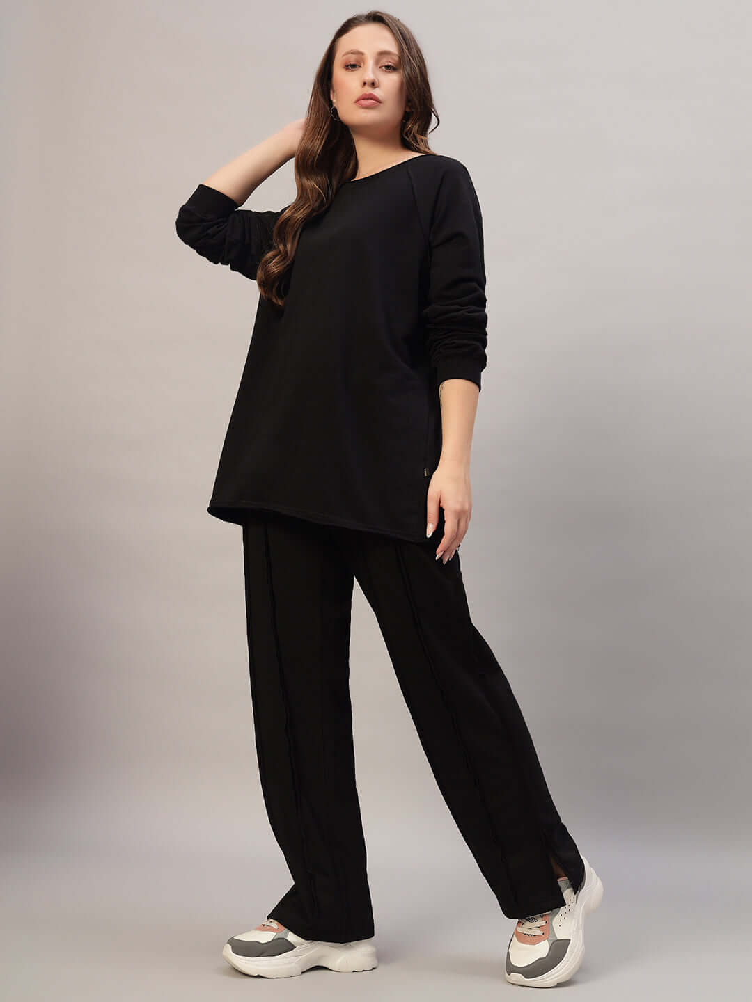 Woman in oversized black co-ord set, relaxed fit joggers with drawstring, showcasing stylish loungewear made of premium 100% cotton.