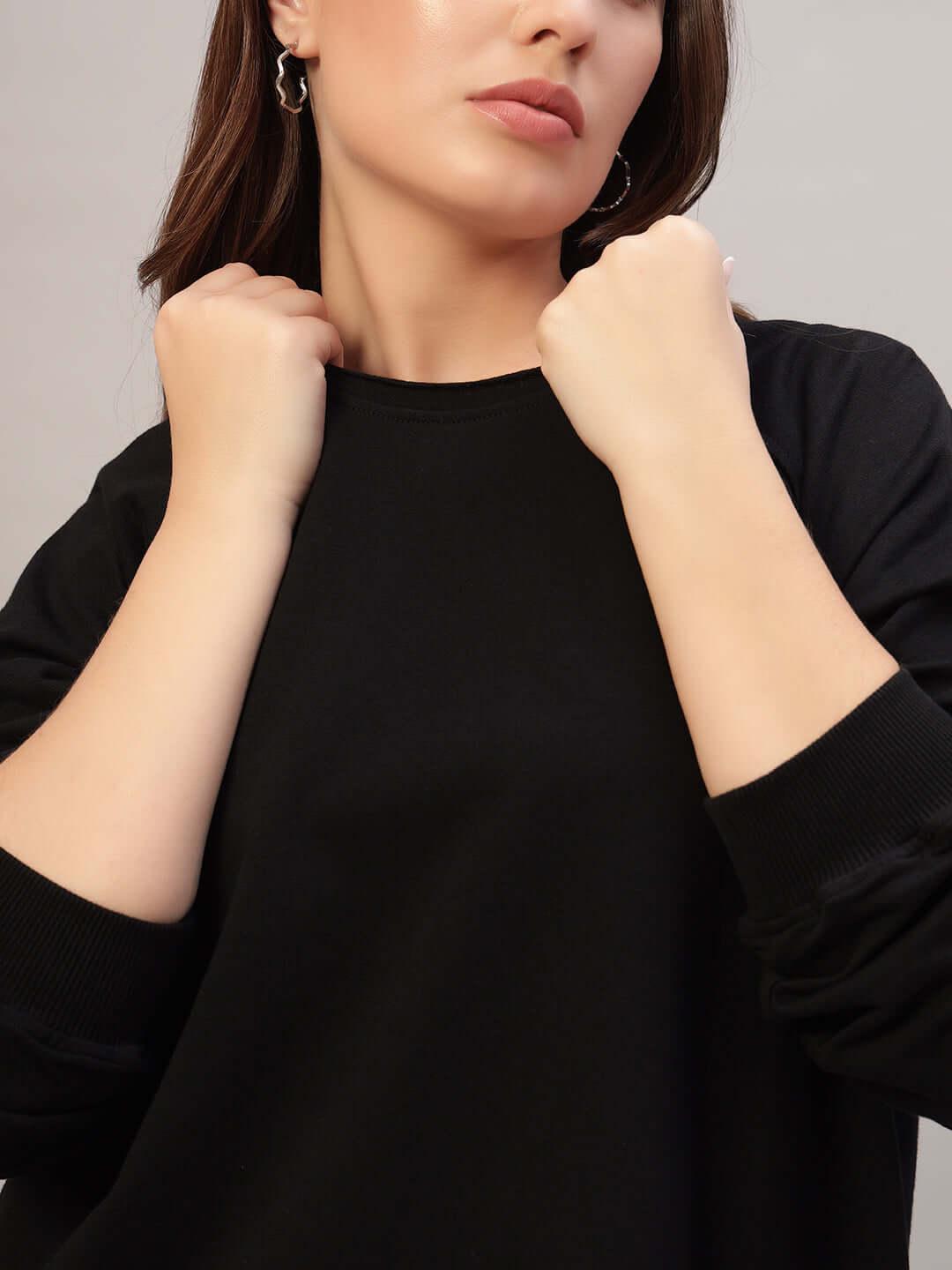 Woman wearing WOMEN LAMINA OVERSIZED SWEATSHIRT BLACK showcasing comfortable, stylish design for modern elegance.