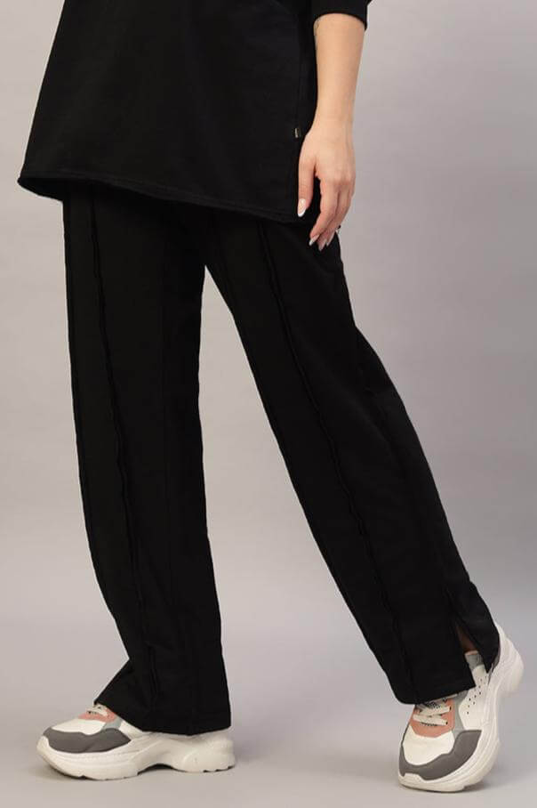 Women's black Lamina side slit joggers, stylish and comfortable, customizable fit available, displayed with casual sneakers.