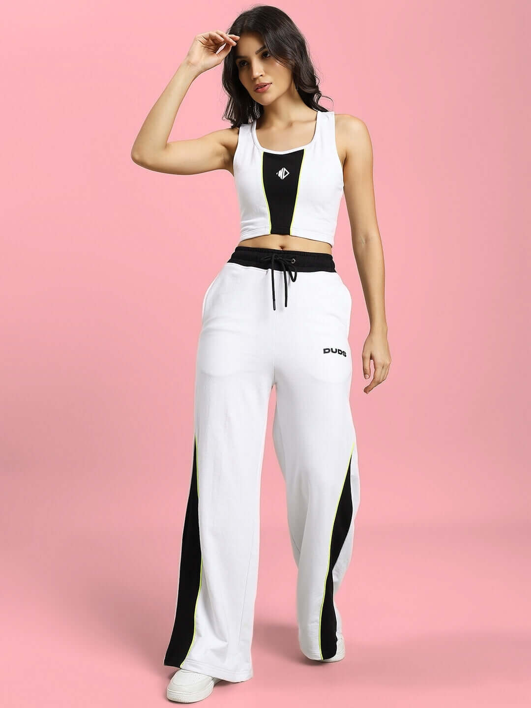 Model wearing WOMENS LARISSA CO-ORD SET WHITE BLACK, showcasing a chic and stylish monochrome design against a light pink background.