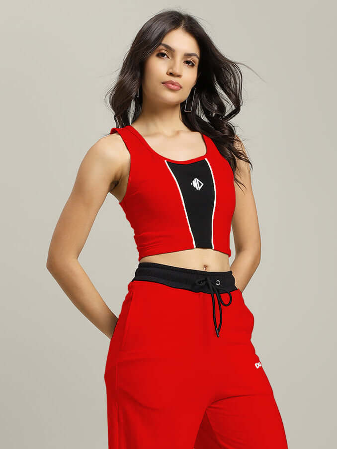 WOMEN LARISSA CROP-TOP RED-BLACK modeled with red pants, featuring a bold color-block design for a stylish statement look.