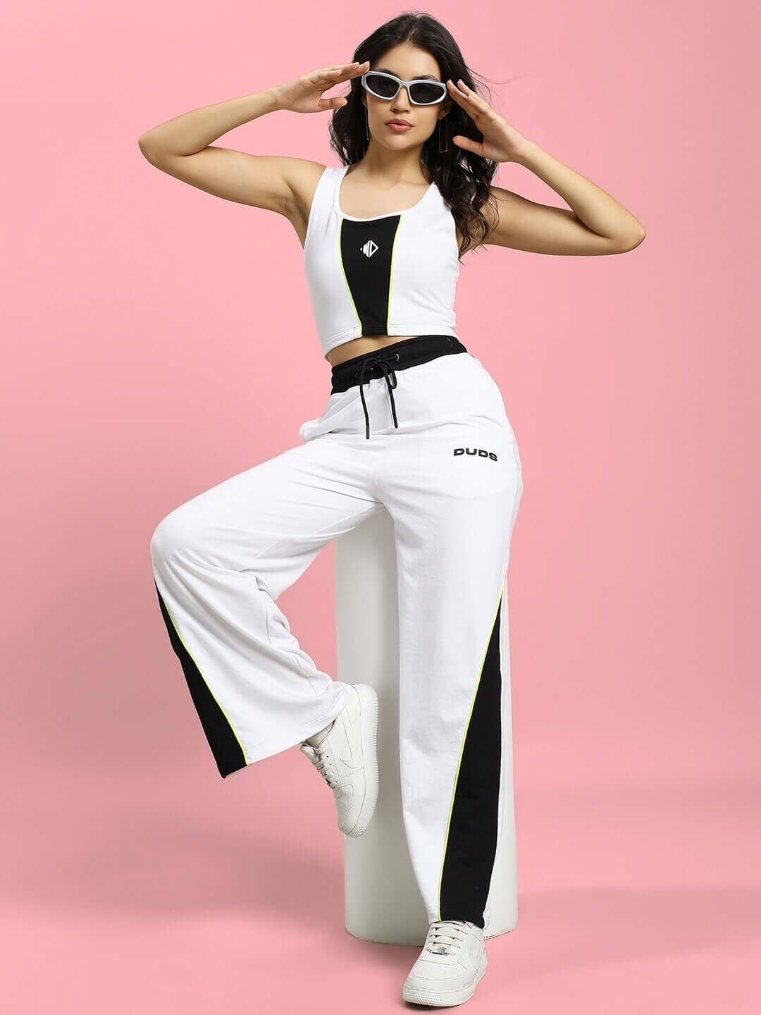 Model wearing Women's Larissa Crop-Top in white and black, styled with matching pants, showcasing a trendy casual fashion look.