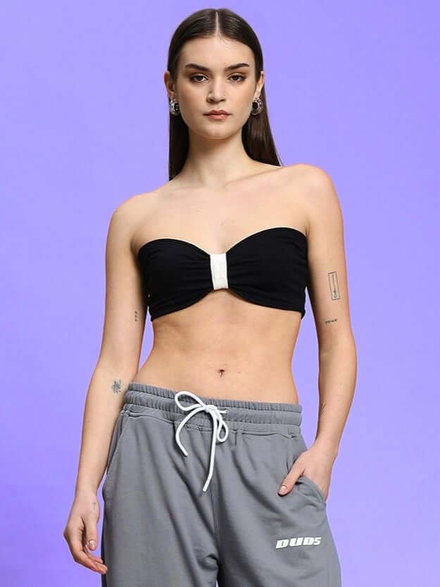Woman wearing WOMEN'S LIA BANDEAU COTTON TOP BLACK with gray sweatpants, stylish and modern fashion ensemble.