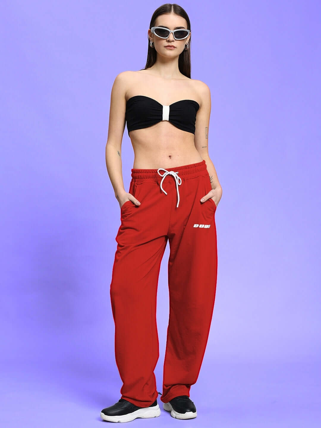 Model wearing WOMEN'S LIA CO-ORD SET BLACK RED with sunglasses on a purple background.