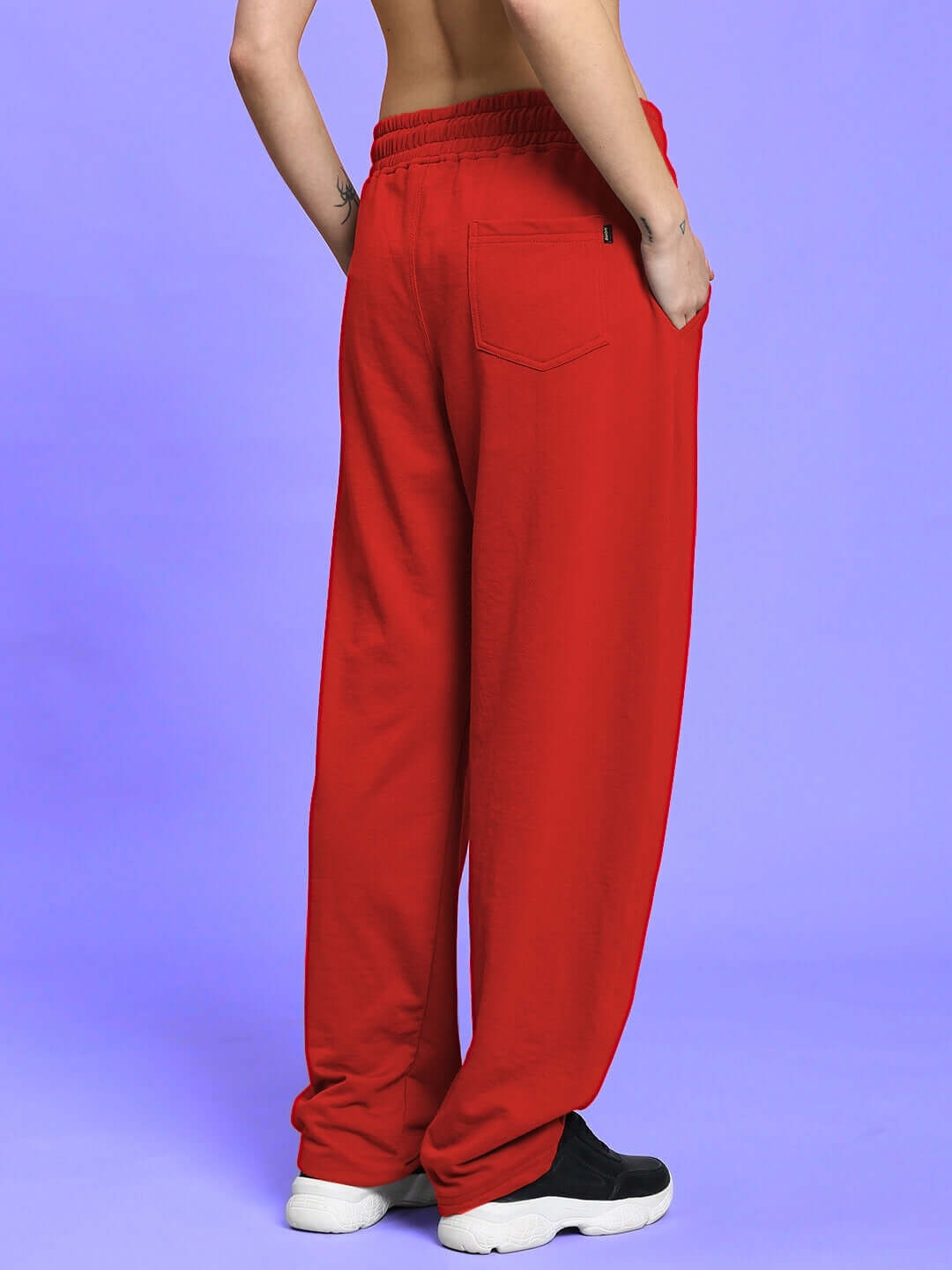 Back view of WOMEN'S LIA CO-ORD SET BLACK RED with vibrant red pants on purple background.