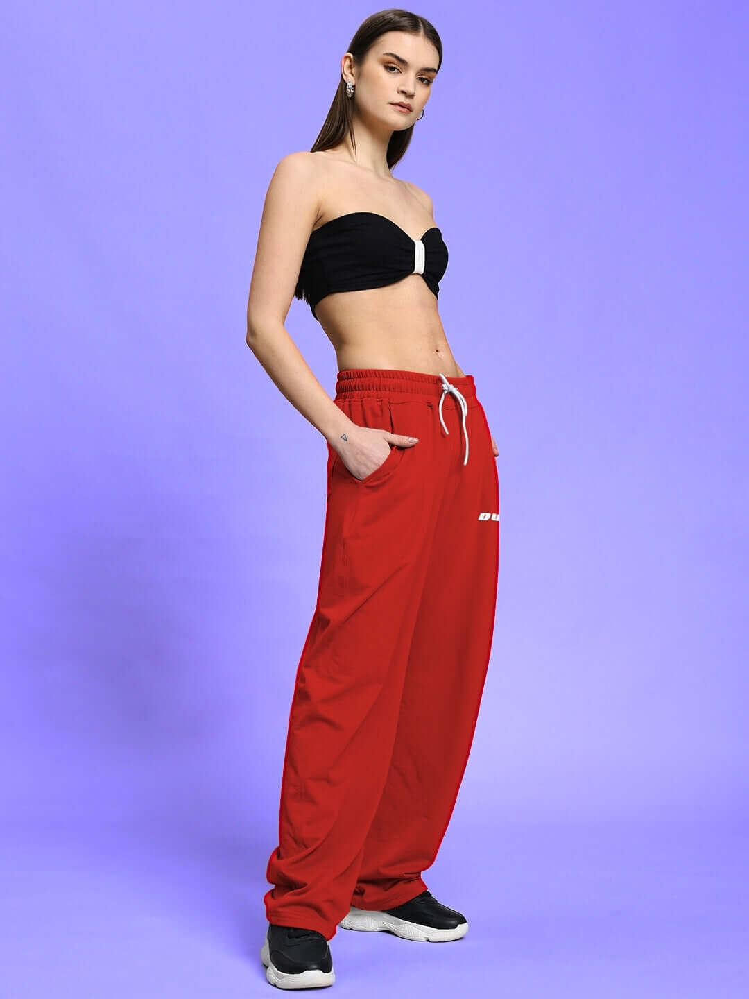 Model wearing WOMEN'S LIA CO-ORD SET BLACK RED with sleek black top and vibrant red pants.