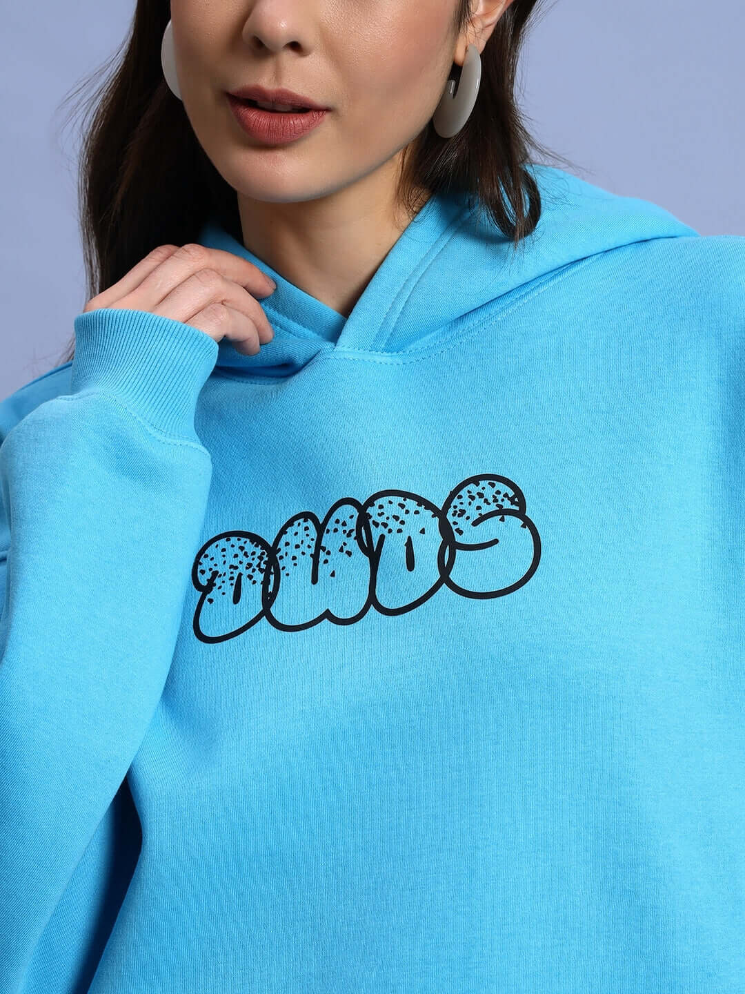Woman wearing WOMEN SHARKWAVE FLEECE OVERSIZED HOODIE LIGHT BLUE with graphic print, showcasing a cozy and stylish design.