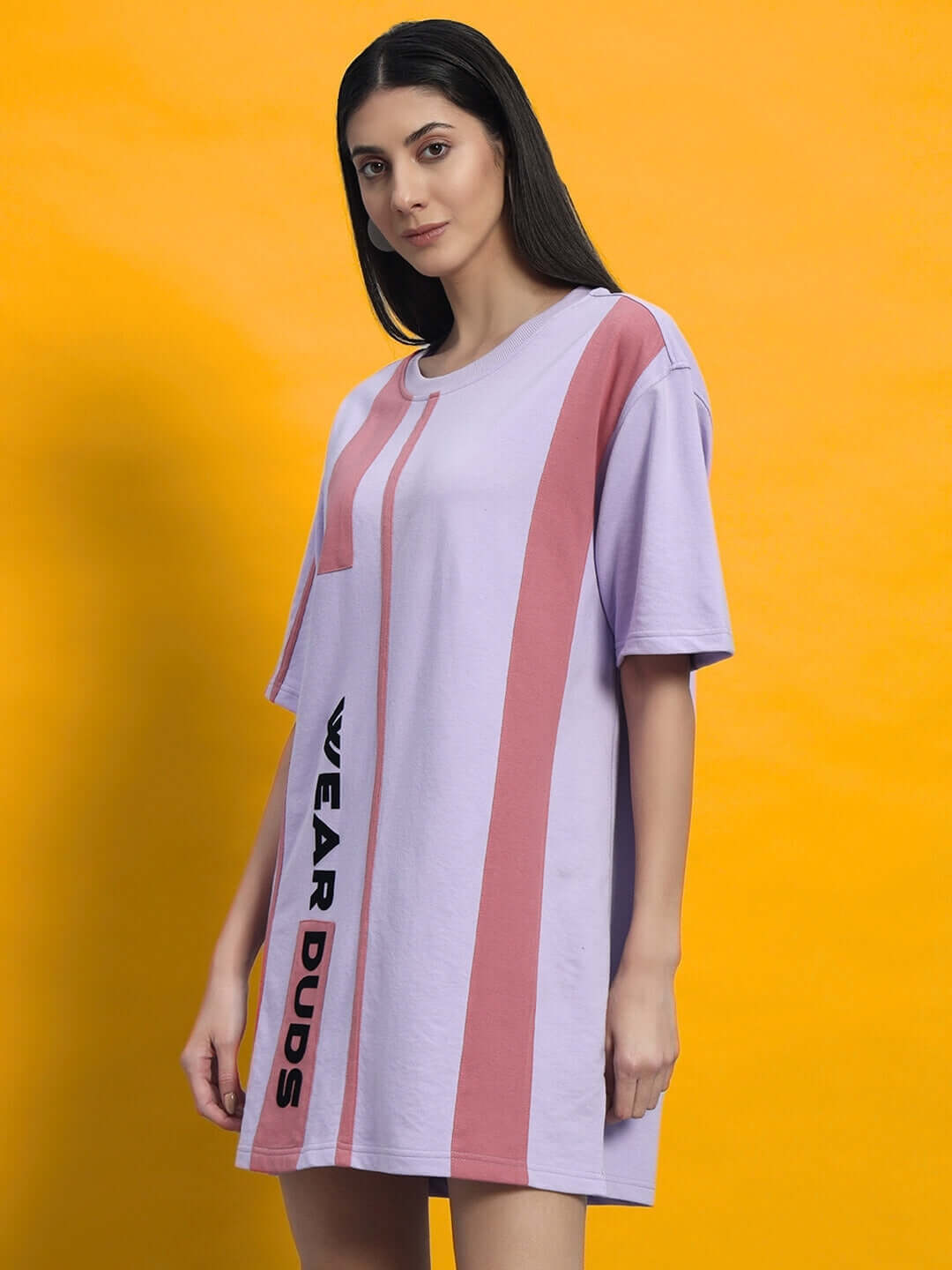 Model wearing a lilac and pink oversized t-shirt dress with 'WEAR DUDS' text on orange background.