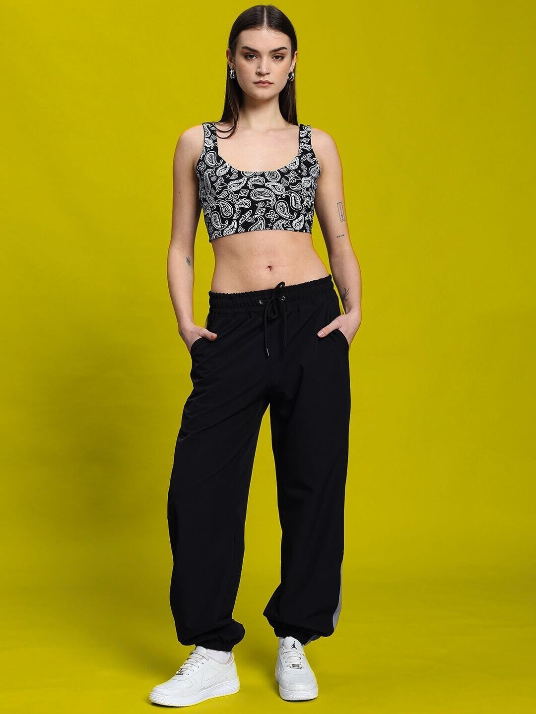 Woman wearing WOMEN'S LINNA CO-ORD SET BLACK from WEAR DUDS on yellow background, showcasing modern elegance.