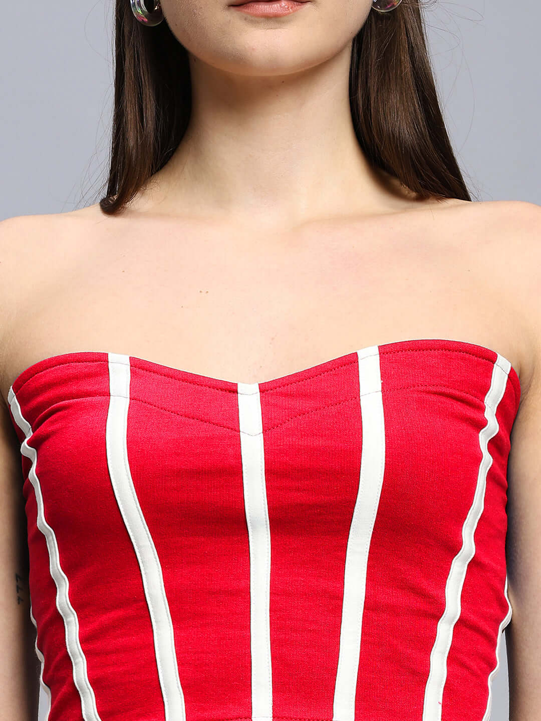 Close-up of a model wearing the WOMEN'S LIVIANA COOL CO-ORD SET RED, showcasing the strapless top's vibrant red and white stripes.